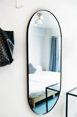 a mirror on a wall next to a bed at Shinjuku central apartment! 3stops to Shibuya station 3mins walk to station in Tokyo