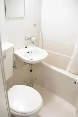 a white bathroom with a sink and a toilet at Shinjuku central apartment! 3stops to Shibuya station 3mins walk to station in Tokyo