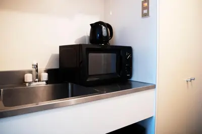 a microwave sitting on top of a kitchen counter at Shinjuku central apartment! 3stops to Shibuya station 3mins walk to station in Tokyo