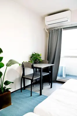 a room with a table and a chair and a window at Shinjuku central apartment! 3stops to Shibuya station 3mins walk to station in Tokyo