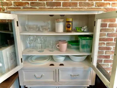 a white cabinet filled with dishes and glasses at \u30e9\u30d5\u30a9\u30ec\uff11\uff10\uff11\u3000\u65b0\u5bbf\u304b\u308913\u5206\u306e\u304f\u3064\u308d\u3052\u308b\u304a\u90e8\u5c4b in Tokyo