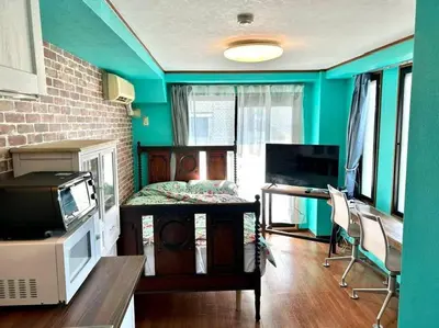 a room with blue walls and a desk with a television at \u30e9\u30d5\u30a9\u30ec\uff11\uff10\uff11\u3000\u65b0\u5bbf\u304b\u308913\u5206\u306e\u304f\u3064\u308d\u3052\u308b\u304a\u90e8\u5c4b in Tokyo