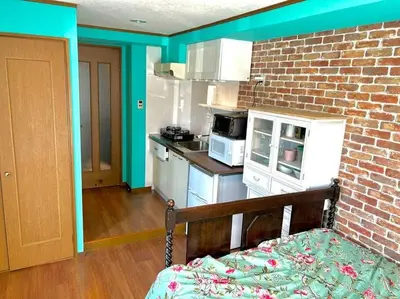 a kitchen with blue walls and a brick wall at \u30e9\u30d5\u30a9\u30ec\uff11\uff10\uff11\u3000\u65b0\u5bbf\u304b\u308913\u5206\u306e\u304f\u3064\u308d\u3052\u308b\u304a\u90e8\u5c4b in Tokyo