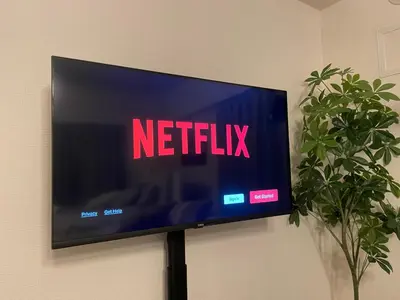 a flat screen tv on a wall with the netflix sign at Oak Stay Shimokitazawa Luxury Family size 2min Shimokitazawa sta Shinjuku Shibuya7min by train in Tokyo