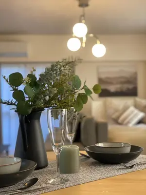 a table with a wine glass and a vase with flowers at Oak Stay Shimokitazawa Luxury Family size 2min Shimokitazawa sta Shinjuku Shibuya7min by train in Tokyo