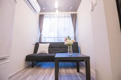 a living room with a black couch and a table at 2mins walk to Ueno station (Tokyo)-YoE9 in Tokyo