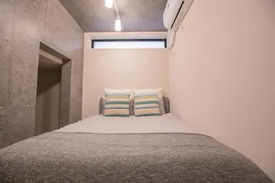 a small bedroom with a bed with two pillows at 2mins walk to Ueno station (Tokyo)-YoE9 in Tokyo