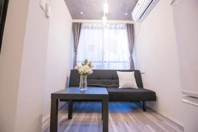 a living room with a couch and a vase of flowers on a table at 2mins walk to Ueno station (Tokyo)-YoE9 in Tokyo