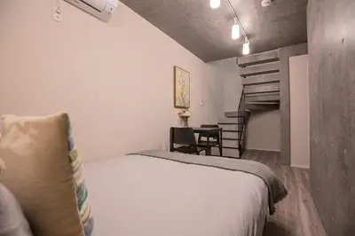 a small bedroom with a bed and a staircase at 2mins walk to Ueno station (Tokyo)-YoE9 in Tokyo