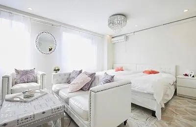 a white bedroom with a bed and a couch at Reimi Mondo501 in Tokyo