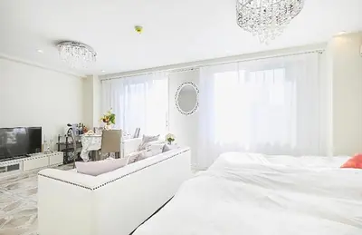 a white bedroom with a bed and a tv at Reimi Mondo501 in Tokyo