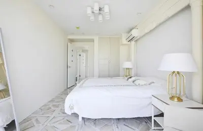 a white bedroom with a large bed and a desk at Reimi Mondo501 in Tokyo
