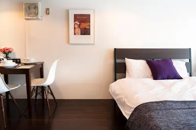 a hotel room with a bed and a table and a desk at #2 3stops to Shinjuku station stylish spacious studio apartment in Tokyo