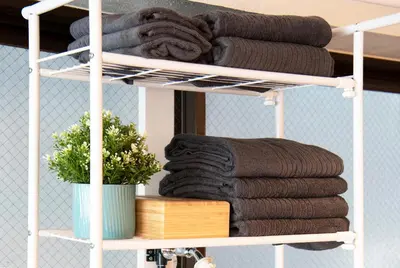 a white towel rack with towels on it at #2 3stops to Shinjuku station stylish spacious studio apartment in Tokyo