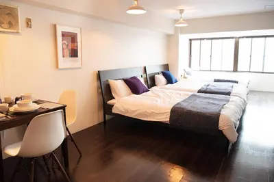 a bedroom with a large bed and a table and chairs at #2 3stops to Shinjuku station stylish spacious studio apartment in Tokyo