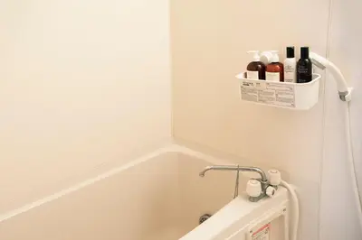 a bathroom with a bath tub with a basket on the wall at #2 3stops to Shinjuku station stylish spacious studio apartment in Tokyo