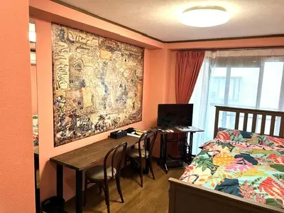 a bedroom with a bed and a table and chairs at \u30e9\u30d5\u30a9\u30ec\uff11\uff10\uff12\u3000\u65b0\u5bbf\u304b\u308913\u5206\u306e\u304f\u3064\u308d\u3052\u308b\u304a\u90e8\u5c4b in Tokyo