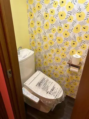 a bathroom with a toilet with a yellow and white shower curtain at \u30e9\u30d5\u30a9\u30ec\uff11\uff10\uff12\u3000\u65b0\u5bbf\u304b\u308913\u5206\u306e\u304f\u3064\u308d\u3052\u308b\u304a\u90e8\u5c4b in Tokyo