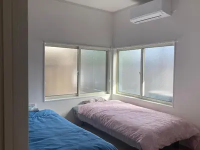 a bedroom with two beds and two windows at Tokyo Skytree Tower\u30fbAsakusa Ashiana Guest House in Tokyo