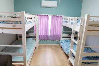 a room with two bunk beds with a window at Tokyo Skytree Tower\u30fbAsakusa Ashiana Guest House in Tokyo