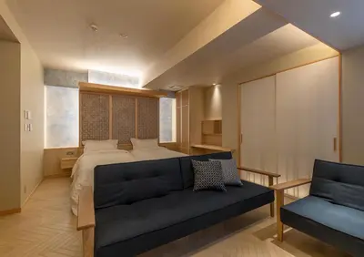 a bedroom with a bed and a blue couch at \u30e2\u30c0\u30f3\u548c\u98a8\u6c11\u5bbf \u7c8bSui \u4e0a\u91ce Asakusa in Tokyo
