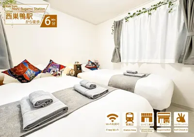 two beds in a hotel room with towels at nestay villa tokyo sugamo in Tokyo