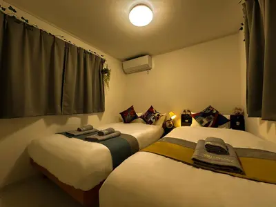 two beds sitting next to each other in a room at nestay villa tokyo sugamo in Tokyo