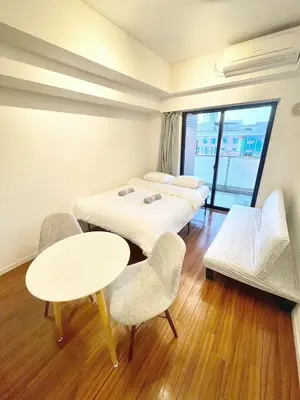 a room with three beds and a table and chairs at \u6b4c\u821e\u4f0e\u753a\u306e\u7269\u4ef65\u968e \u6771\u65b0\u5bbf\u99c5\u5f92\u6b693\u5206\u65b0\u5bbf\u6e0b\u8c37\u539f\u5bbf\u30a8\u30ea\u30a2 in Tokyo