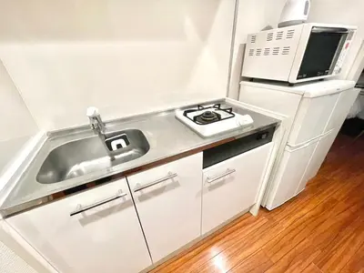 a small kitchen with a sink and a microwave at \u6b4c\u821e\u4f0e\u753a\u306e\u7269\u4ef65\u968e \u6771\u65b0\u5bbf\u99c5\u5f92\u6b693\u5206\u65b0\u5bbf\u6e0b\u8c37\u539f\u5bbf\u30a8\u30ea\u30a2 in Tokyo
