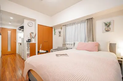 a bedroom with a large white bed with a pink pillow at \u65b0\u5bbf\u6b4c\u821e\u4f0e\u753a\u97e9\u56fd\u5e7f\u573a\u623f\u6e90\u514d\u8d39Wi-Fi in Tokyo