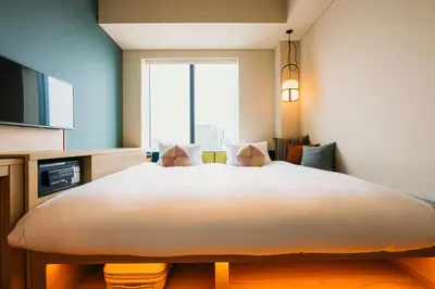a large bed in a room with a large window at OMO5 Tokyo Gotanda by Hoshino Resorts in Tokyo