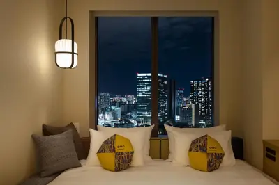a bedroom with a bed with a view of a city at OMO5 Tokyo Gotanda by Hoshino Resorts in Tokyo