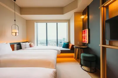 a hotel room with two beds and a tv at OMO5 Tokyo Gotanda by Hoshino Resorts in Tokyo