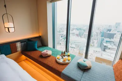 a hotel room with a bed and a tray of food at OMO5 Tokyo Gotanda by Hoshino Resorts in Tokyo