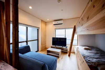 a room with a bunk bed and a couch and a tv at \u3010Hotel Futaba HeightsC\u3011good access, up to 5 guests in Tokyo