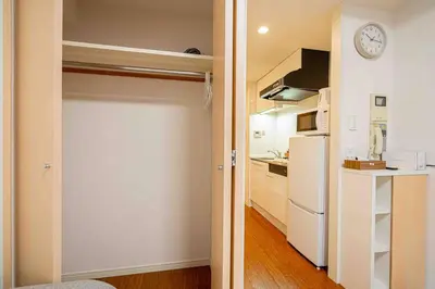 a door to a kitchen with a refrigerator and a clock at \u65b0\u5bbf\u533a\u6b4c\u821e\u4f0e\u753a\u8212\u9002\u9732\u53f0\u623f\u6e90\u5f92\u6b653\u5206\u949f\u5730\u94c1\u7ad9 in Tokyo
