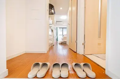 two pairs of shoes sitting on the floor in a hallway at \u65b0\u5bbf\u533a\u6b4c\u821e\u4f0e\u753a\u8212\u9002\u9732\u53f0\u623f\u6e90\u5f92\u6b653\u5206\u949f\u5730\u94c1\u7ad9 in Tokyo
