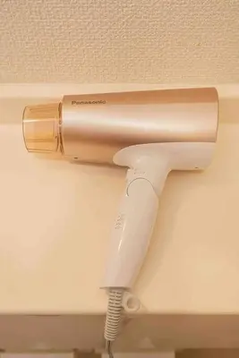 a hair dryer attached to a wall with a cord at \u65b0\u5bbf\u533a\u6b4c\u821e\u4f0e\u753a\u8212\u9002\u9732\u53f0\u623f\u6e90\u5f92\u6b653\u5206\u949f\u5730\u94c1\u7ad9 in Tokyo
