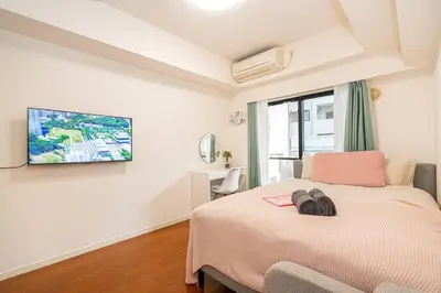 a bedroom with a bed and a tv on the wall at \u65b0\u5bbf\u533a\u6b4c\u821e\u4f0e\u753a\u8212\u9002\u9732\u53f0\u623f\u6e90\u5f92\u6b653\u5206\u949f\u5730\u94c1\u7ad9 in Tokyo
