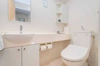 a white bathroom with a toilet and a sink at \u65b0\u5bbf\u533a\u6b4c\u821e\u4f0e\u753a\u8212\u9002\u9732\u53f0\u623f\u6e90\u5f92\u6b653\u5206\u949f\u5730\u94c1\u7ad9 in Tokyo