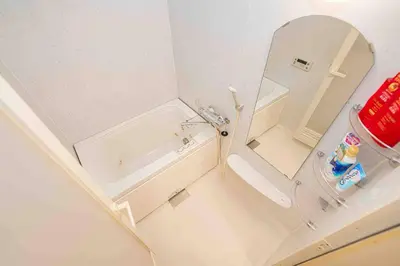 a small bathroom with a tub and a mirror at \u65b0\u5bbf\u533a\u6b4c\u821e\u4f0e\u753a\u8212\u9002\u9732\u53f0\u623f\u6e90\u5f92\u6b653\u5206\u949f\u5730\u94c1\u7ad9 in Tokyo