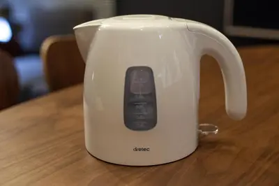 a white tea kettle with a remote control on a table at Lucky Aoto \u30e9\u30c3\u30ad\u30fc\u9752\u6238 in Tokyo