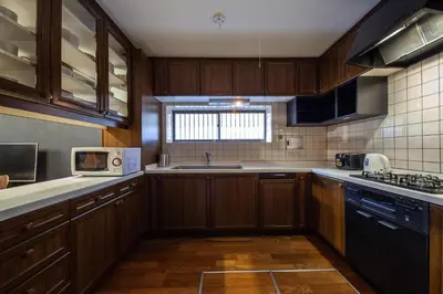 a kitchen with wooden cabinets and a sink and a microwave at Lucky Aoto \u30e9\u30c3\u30ad\u30fc\u9752\u6238 in Tokyo