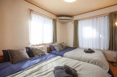 a bedroom with two beds and a window at Lucky Higashimizue \u30e9\u30c3\u30ad\u30fc\u6771\u745e\u6c5f in Tokyo