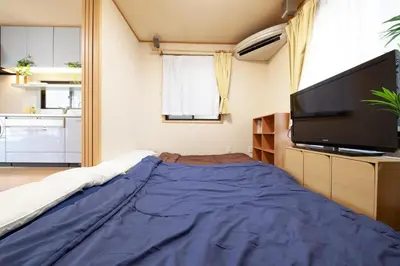 a bedroom with a large flat screen tv and a bed at Lucky Higashimizue \u30e9\u30c3\u30ad\u30fc\u6771\u745e\u6c5f in Tokyo