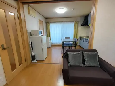 a living room with a couch and a kitchen with a table at Lucky Higashimizue \u30e9\u30c3\u30ad\u30fc\u6771\u745e\u6c5f in Tokyo