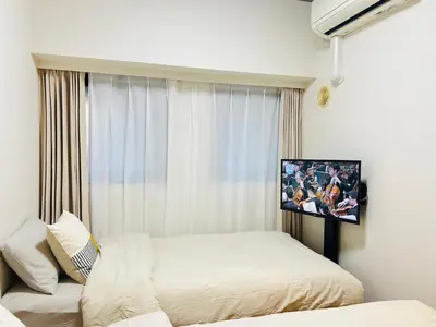a bedroom with two beds and a tv on the wall at JUN Kabukicho-SJ0096 in Tokyo