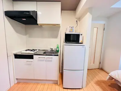 a small kitchen with a microwave and a refrigerator at JUN Kabukicho-SJ0096 in Tokyo