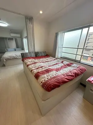 a bedroom with a large bed and a window at QQ Umeyashiki in Tokyo