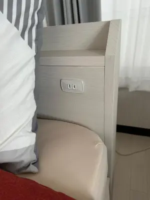 a night stand next to a bed in a room at QQ Umeyashiki in Tokyo